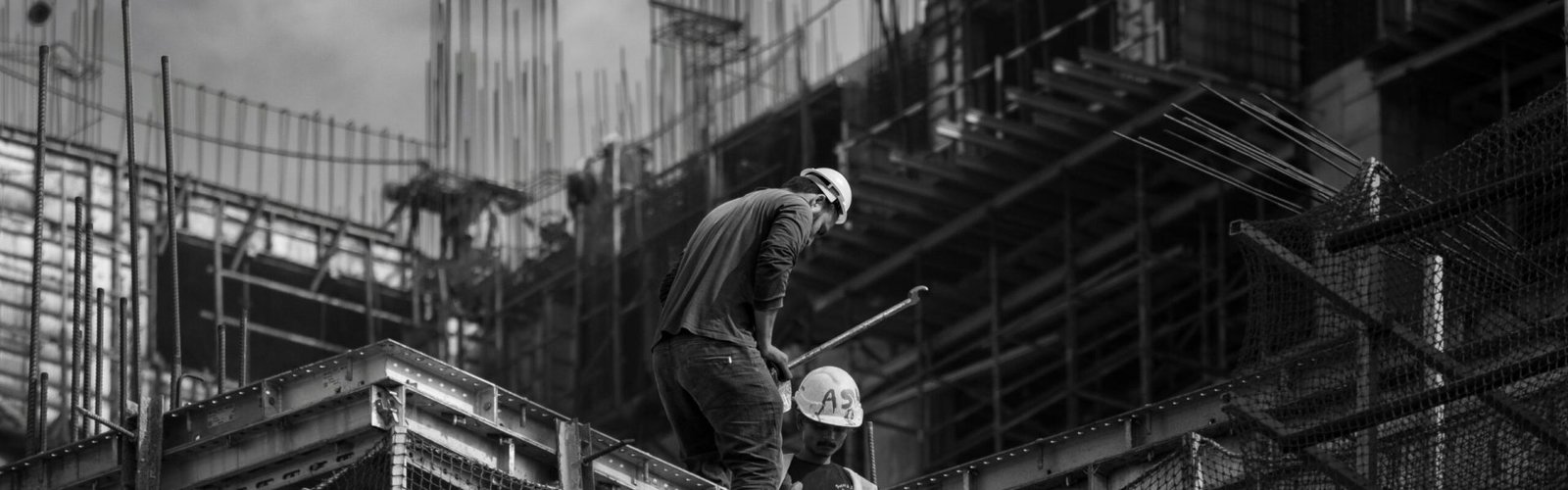Black and white photo showing construction workers on an urban building site.